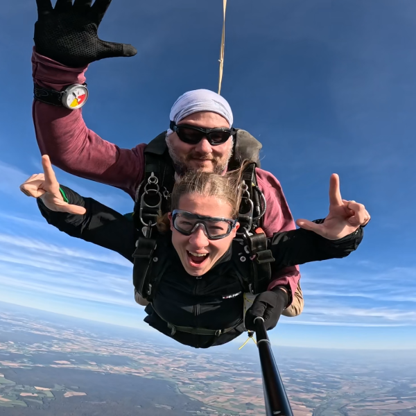 Deux parachutistes en chute libre, souriants, pouce levé