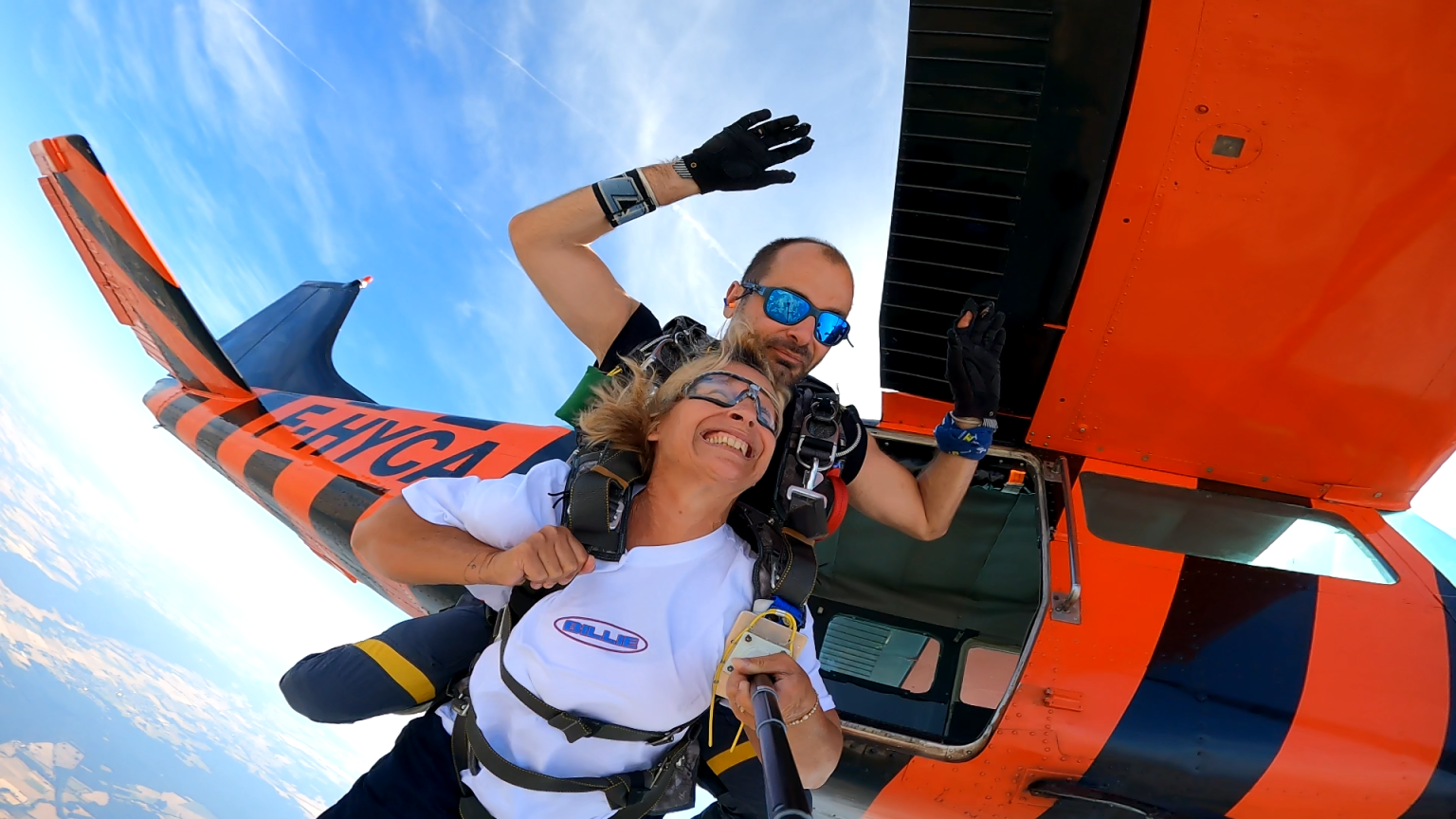 Passagère souriante à la porte de l’avion, harnachée à son moniteur